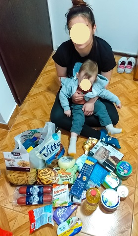 Mum and baby receiving Easter parcel of foods and medicines